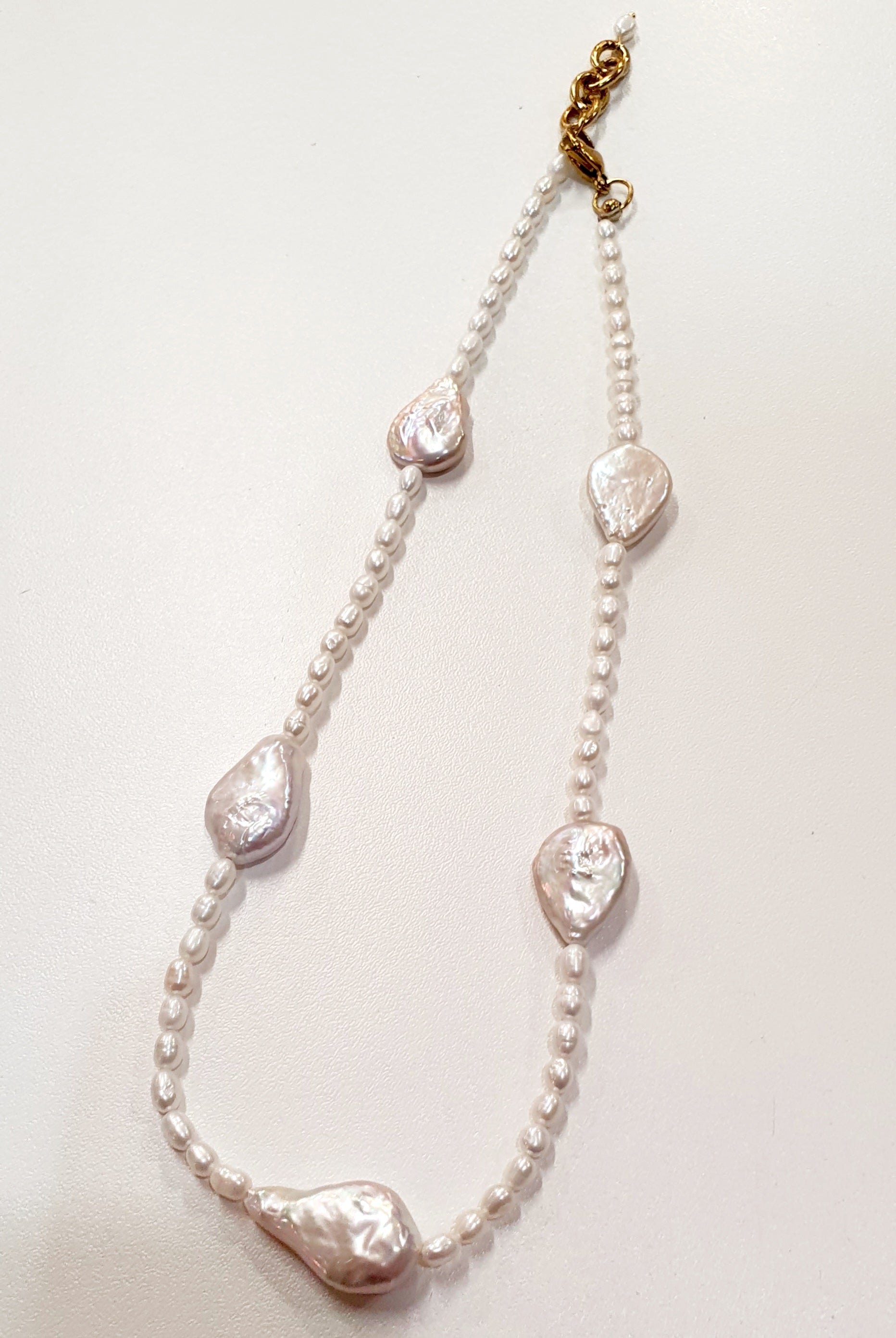 Harmony Pearl Necklace


Handgemaakte halsketting met zoetwaterparels &amp; verguld roestvrij staal


Deze JES Harmony Pearl Necklace is een verfijnde, handgemaakte halsketting waarin echte zoetwaterparels en barokke parels worden gecombineerd met vergulde roestvrijstalen sluitingen en afwerkingen. Het ontwerp straalt natuurlijke elegantie uit en brengt klassieke parels samen met een moderne, asymmetrische vormgeving.


De afwisseling van kleine, ronde parels en grotere barokparels zorgt voor een unieke com