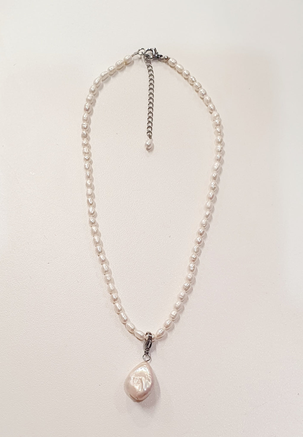 De JES Original Princess Barok is een ode aan natuurlijke elegantie en vrouwelijke kracht.
Deze artisanale zoetwaterparel set werd met de hand samengesteld uit zorgvuldig geselecteerde parels, elk met een eigen vorm, glans en karakter. Geen twee parels zijn identiek — precies daarin schuilt haar schoonheid.


De ketting bestaat uit 68 echte zoetwaterparels, harmonieus geregen tot een verfijnde streng. Centraal hangt een barokke parel, puur en expressief, die afneembaar is via een discreet slotje. Zo draagt 