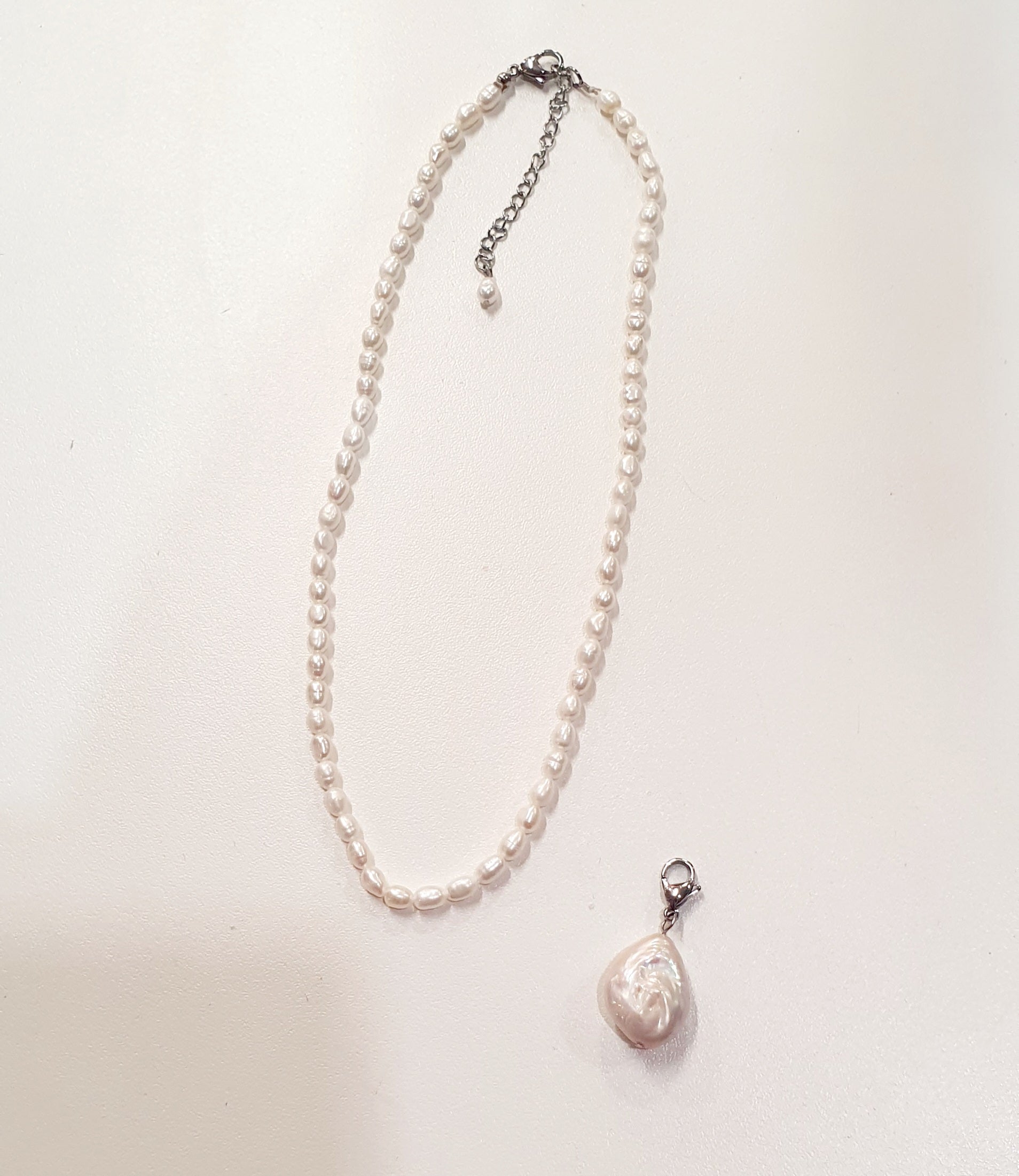 De JES Original Princess Barok is een ode aan natuurlijke elegantie en vrouwelijke kracht.
Deze artisanale zoetwaterparel set werd met de hand samengesteld uit zorgvuldig geselecteerde parels, elk met een eigen vorm, glans en karakter. Geen twee parels zijn identiek — precies daarin schuilt haar schoonheid.


De ketting bestaat uit 68 echte zoetwaterparels, harmonieus geregen tot een verfijnde streng. Centraal hangt een barokke parel, puur en expressief, die afneembaar is via een discreet slotje. Zo draagt 