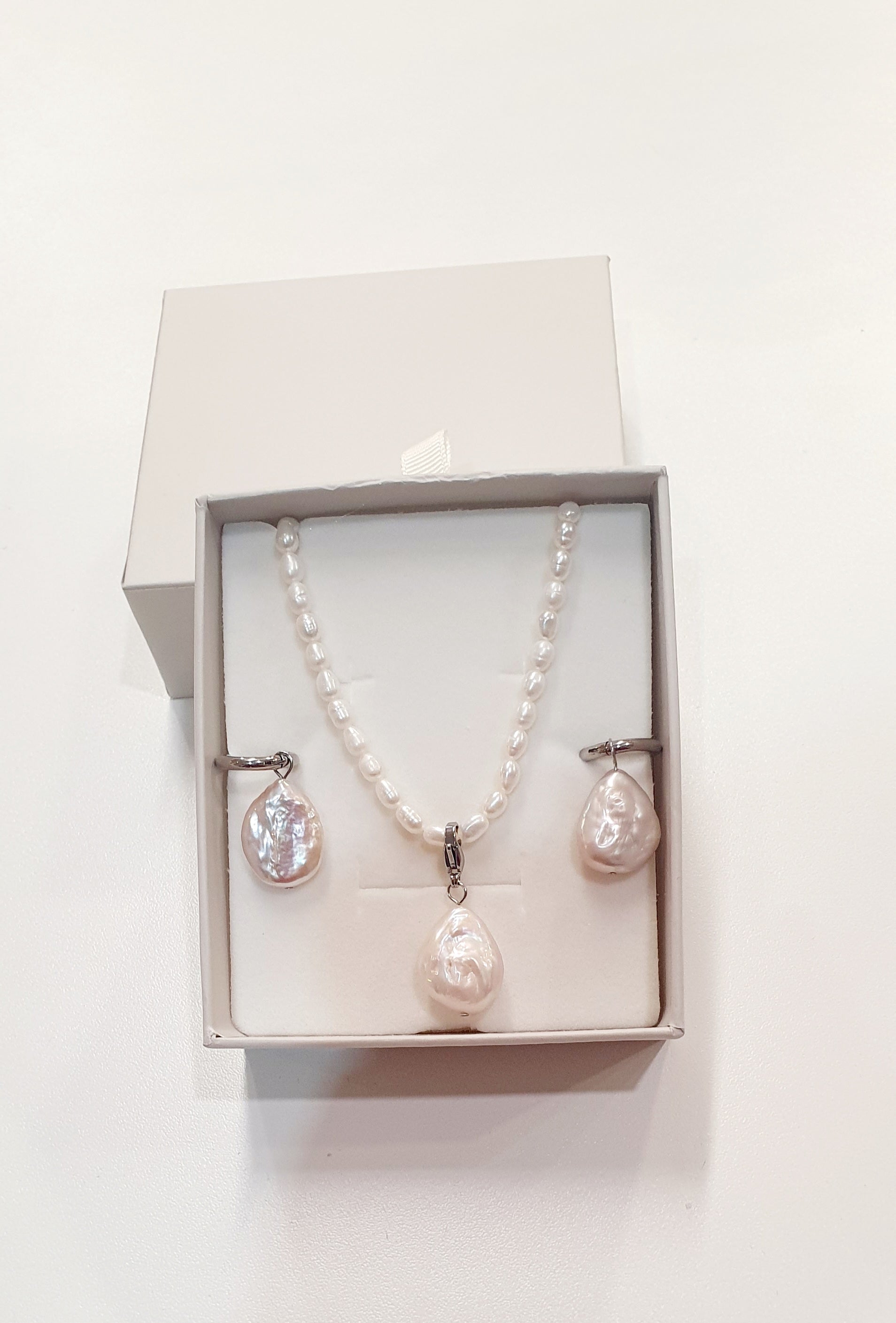 De JES Original Princess Barok is een ode aan natuurlijke elegantie en vrouwelijke kracht.
Deze artisanale zoetwaterparel set werd met de hand samengesteld uit zorgvuldig geselecteerde parels, elk met een eigen vorm, glans en karakter. Geen twee parels zijn identiek — precies daarin schuilt haar schoonheid.


De ketting bestaat uit 68 echte zoetwaterparels, harmonieus geregen tot een verfijnde streng. Centraal hangt een barokke parel, puur en expressief, die afneembaar is via een discreet slotje. Zo draagt 